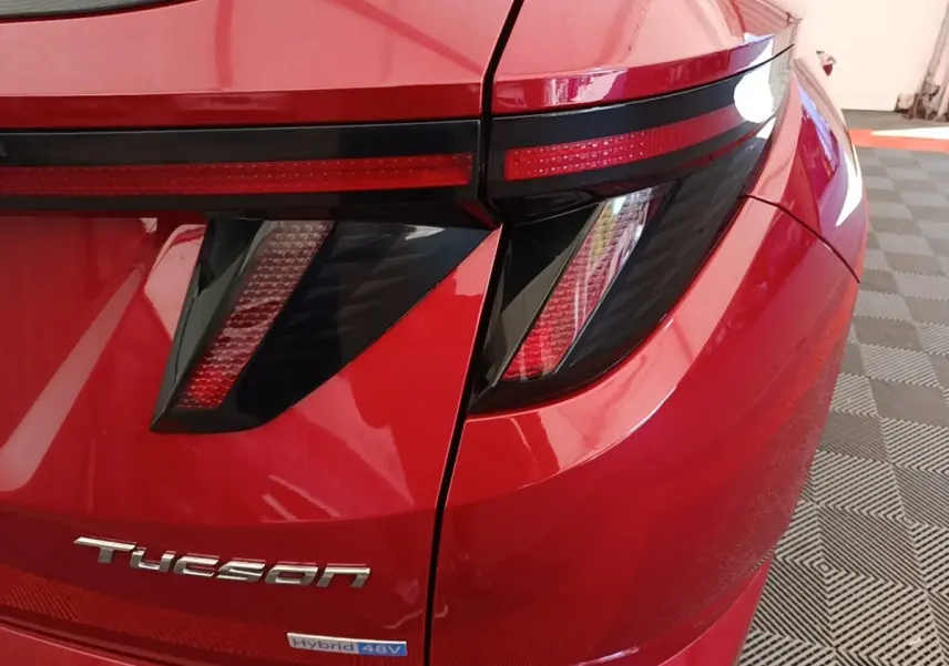Gros plan sur l'arrière droit rouge du Hyundai Tucson avec feux arrière LED et logo Tucson visible.