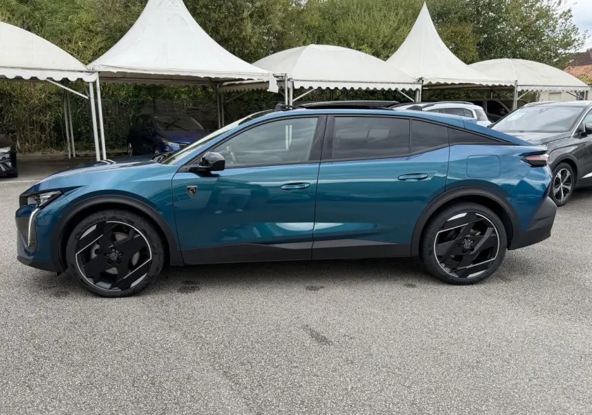 Peugeot 408 PHEV 225 GT bleu vue de profil côté gauche, avec jantes noires et toit panoramique ouvert.