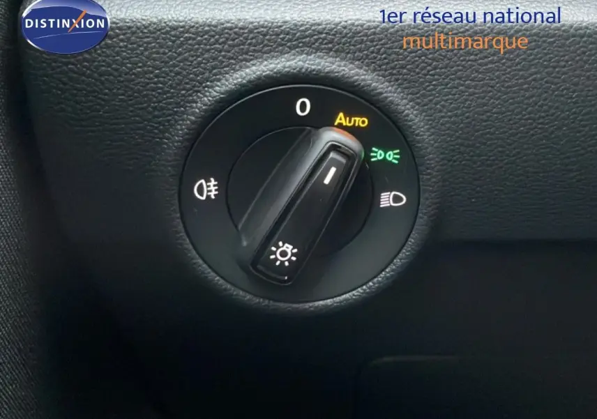 Gros plan sur le bouton de commande des phares du Volkswagen T-Roc 1.5 TSI noir Grenadilla, avec mode automatique activé.