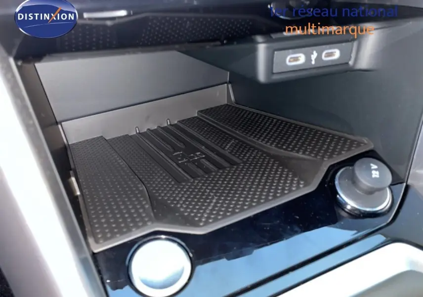 Gros plan sur la console centrale noire du Volkswagen T-Roc avec prise USB et prise 12V visible.