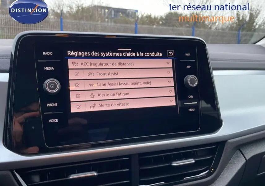 Écran tactile central du tableau de bord du Volkswagen T-Roc noir, affichant les réglages d’aide à la conduite.