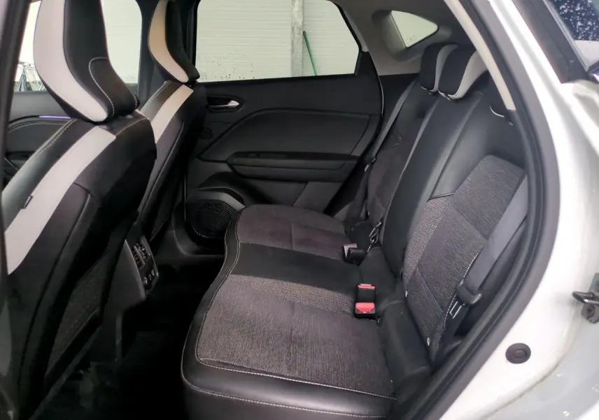Vue intérieure côté droit des sièges arrière noirs et gris du Renault Captur blanc 2024 avec appuis-têtes réglables.