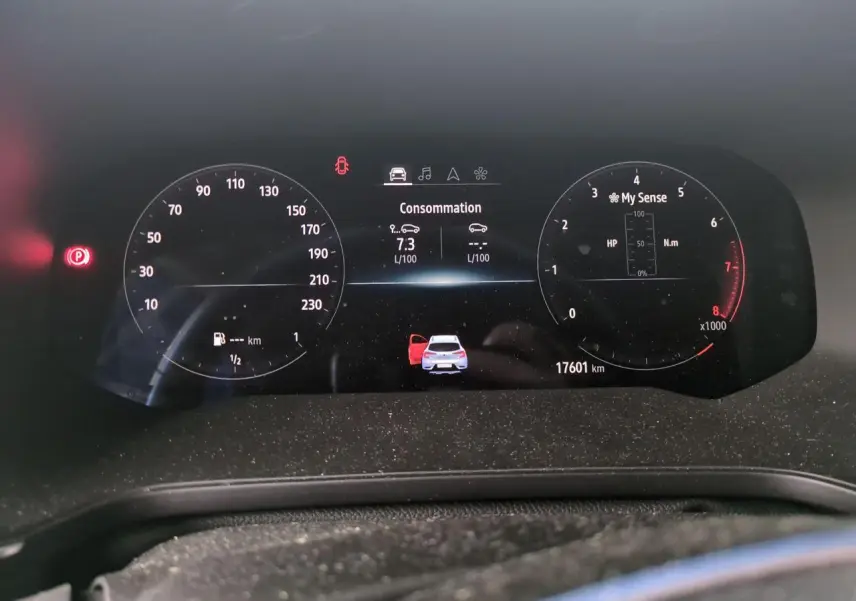 Tableau de bord numérique du Renault Captur blanc 2024 affichant consommation et porte avant gauche ouverte.