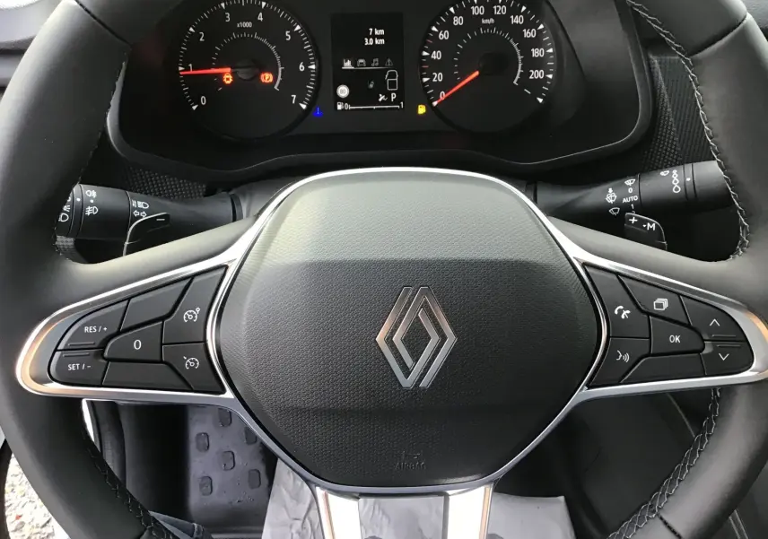 Vue rapprochée du volant noir du Renault Trafic Fourgon 2025 avec commandes intégrées et tableau de bord digital.