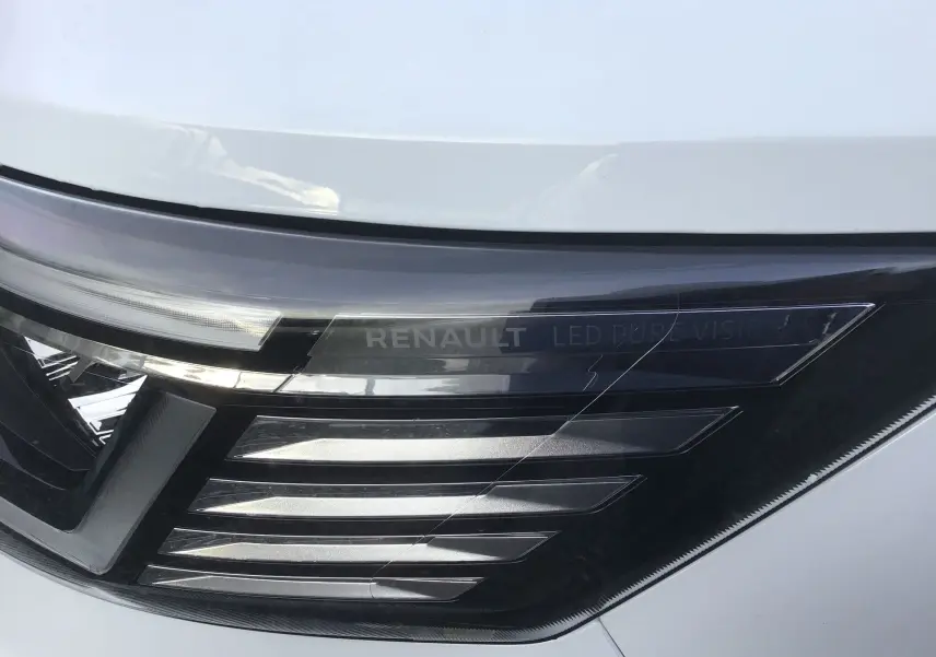 Gros plan sur le phare avant droit blanc du Renault Trafic Fourgon 2025 avec inscription LED Pure Vision.
