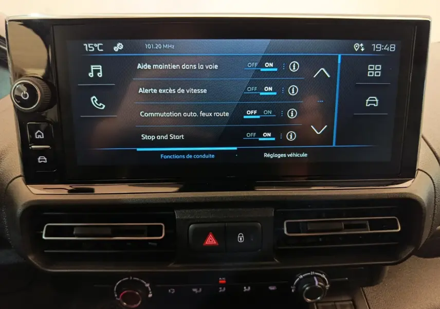 Écran tactile central du Peugeot Partner 2025 montrant les réglages d’aides à la conduite, avec commandes climatisation en dessous.