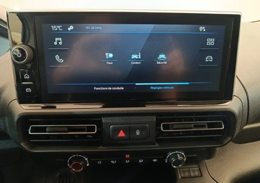 Vue rapprochée de l’écran tactile central et des commandes de climatisation du Peugeot Partner blanc 2025.