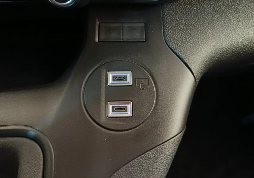 Vue rapprochée des ports USB-C doubles intégrés dans la console centrale noire du Peugeot Partner blanc 2025.