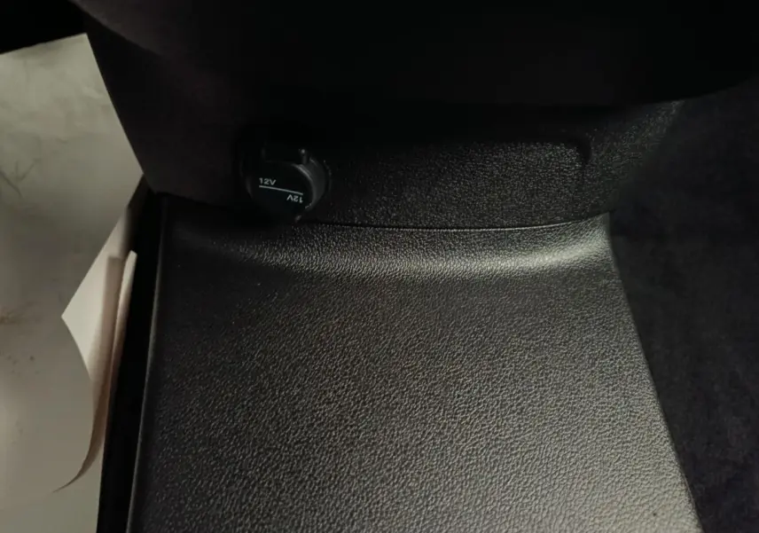 Prise 12V noire sous le siège passager du Peugeot Partner Taille M 650kg Diesel 2025, intérieur sobre.