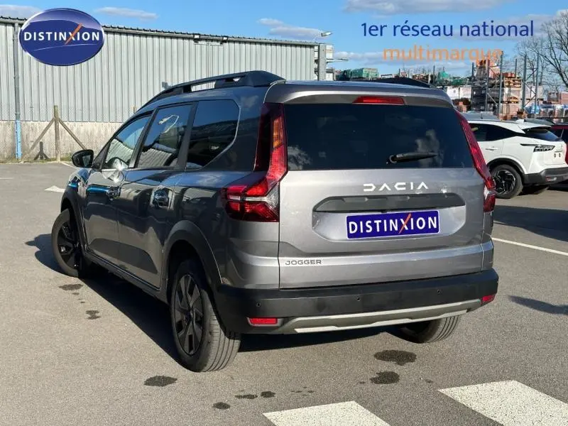 Vue 3/4 arrière droite du Dacia Jogger gris schiste métallisé, version 7 places, stationné en extérieur.