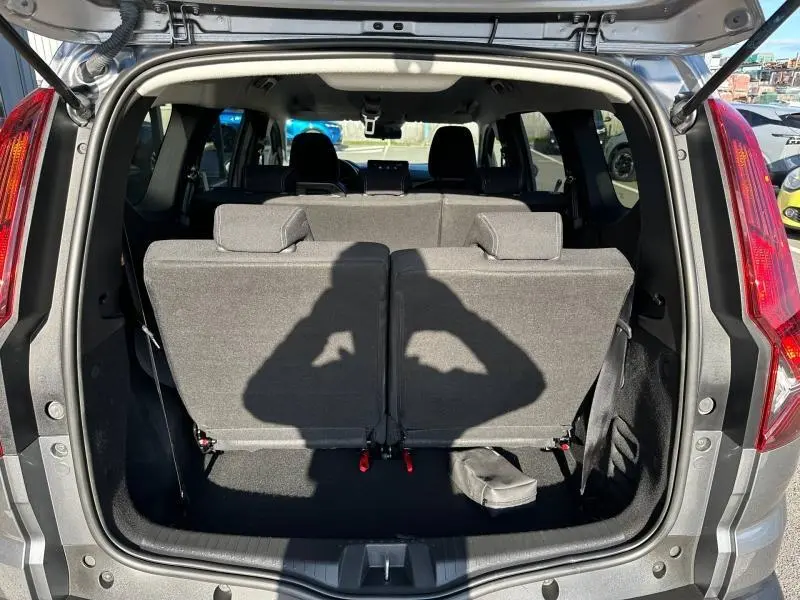 Vue arrière du coffre ouvert du Dacia Jogger gris schiste métallisé, montrant les sièges arrière relevés sur ce modèle 7 places.