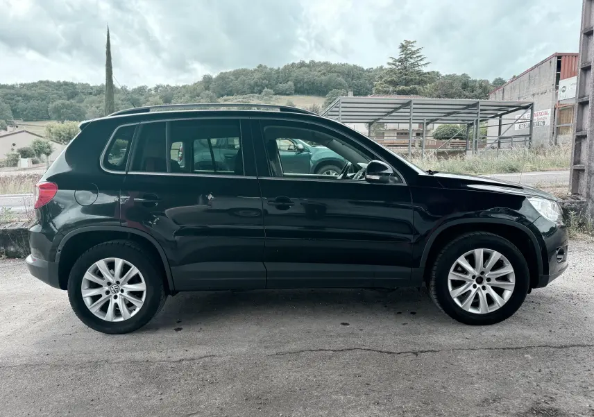 Vue latérale droite d'un Volkswagen Tiguan noir de 2007, avec jantes alliage et carrosserie propre.