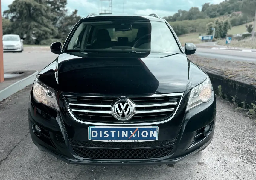 Vue avant d’un Volkswagen Tiguan noir 2007 avec calandre chromée et plaque d’immatriculation Distinxion.