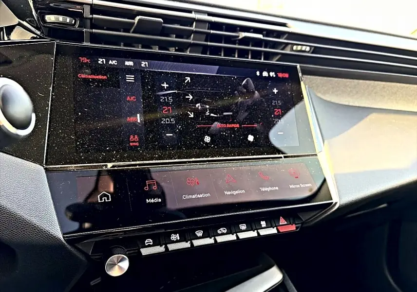 Vue rapprochée de la console centrale tactile du Peugeot 408 Hybrid 145 allure noir, affichant la climatisation et les commandes multimédia.