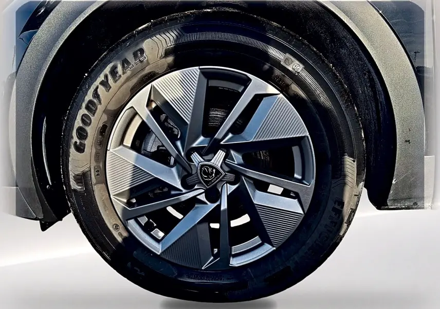 Gros plan sur la roue avant droite du Peugeot 408 noir, mettant en valeur la jante alu au design moderne.