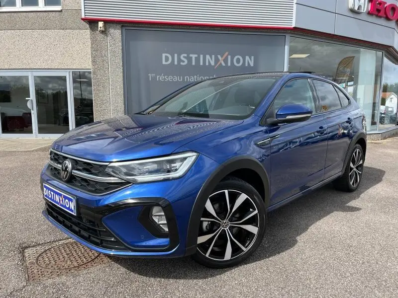 Volkswagen Taigo 1.5 TSI R-Line bleu récif métallisé, vue 3/4 avant droit avec jantes alliage et calandre distinctive.