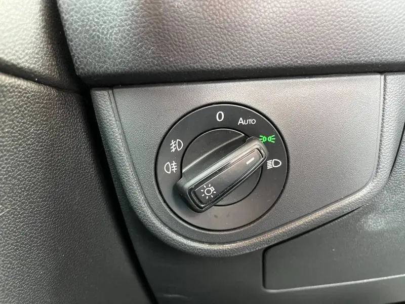 Gros plan sur la commande des phares du Volkswagen Taigo 1.5 TSI R-Line 2023, finition noire mate.