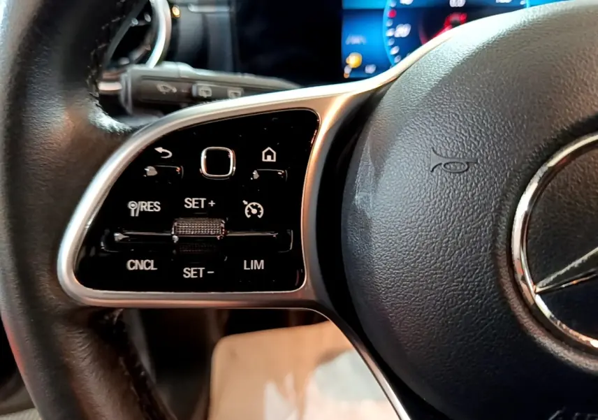 Gros plan sur le volant cuir noir de la Mercedes Classe A 180 d Business Line 2021 avec commandes multifonctions.