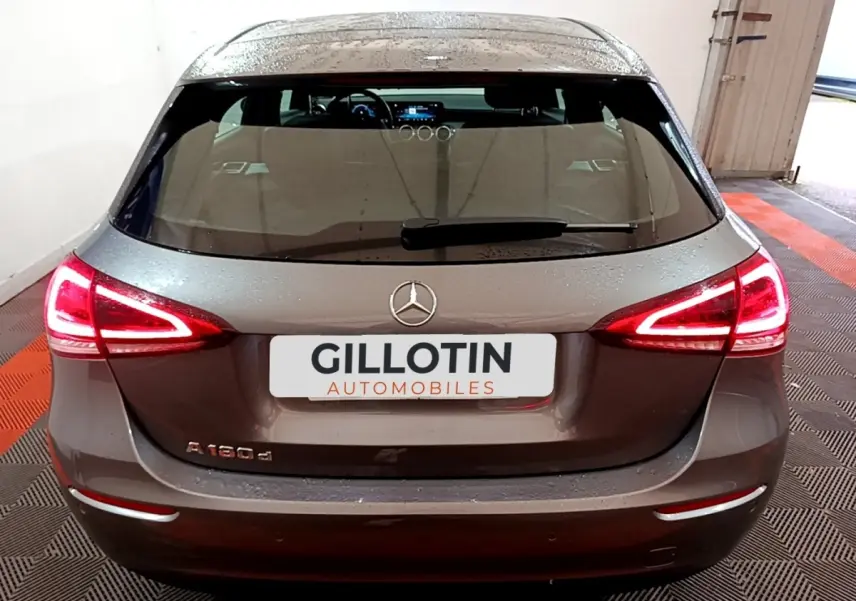 Vue arrière d'une Mercedes Classe A 180 d gris foncé avec feux LED allumés dans un garage.