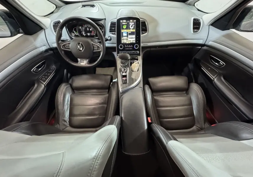 Vue intérieure avant du Renault Espace 2015 gris foncé, avec tableau de bord moderne et écran tactile vertical central.