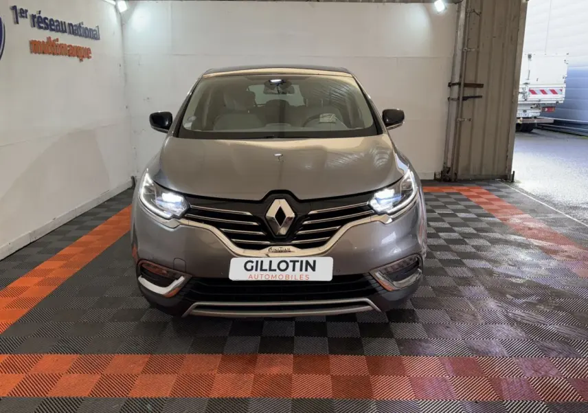Vue avant d'un Renault Espace gris foncé 2015 avec phares LED allumés dans un garage éclairé.