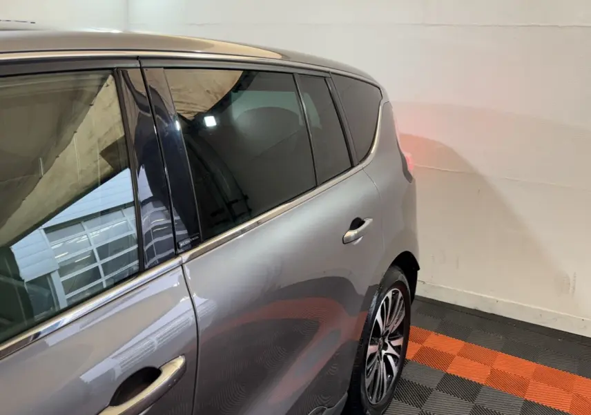 Vue côté gauche arrière d’un Renault Espace gris foncé avec vitres teintées et jantes alliage distinctives.