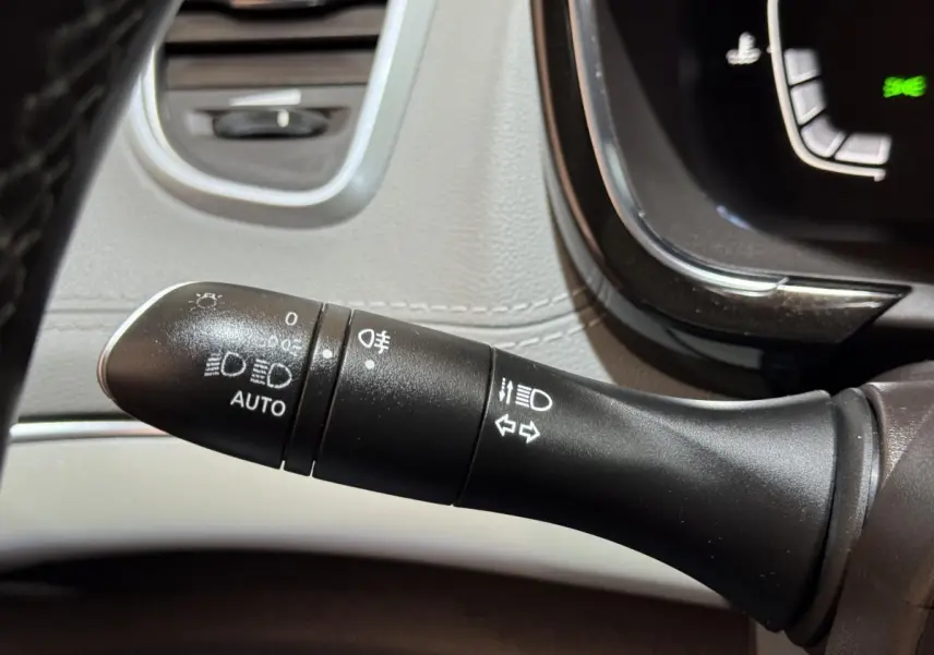Gros plan sur la commande des phares et clignotants dans l’habitacle gris clair d’un Renault Espace 2015 Initiale Paris.