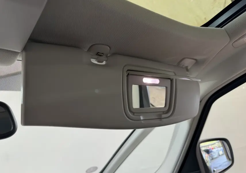 Miroir de courtoisie éclairé sur pare-soleil côté conducteur dans l’habitacle d’un Renault Espace gris foncé.