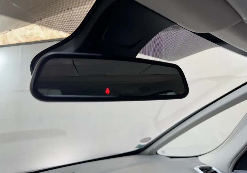 Vue intérieure sur le rétroviseur central d’un Renault Espace gris foncé 2015 avec alerte de ceinture rouge allumée.