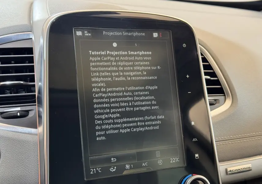 Gros plan sur l'écran tactile central du tableau de bord beige du Renault Espace Initiale Paris 2015 affichant un tutoriel smartphone.