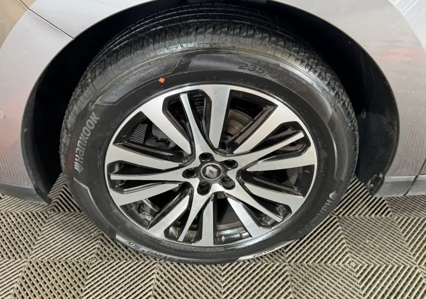 Gros plan sur la roue avant droite gris foncé de la Renault Espace Initiale Paris avec jante alliage bicolore et logo Renault central.