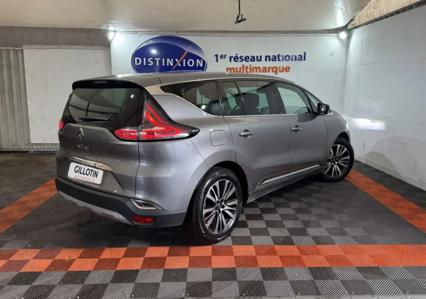 Renault Espace gris foncé vue 3/4 arrière droit, feux arrière LED et jantes alliage visibles en intérieur showroom.