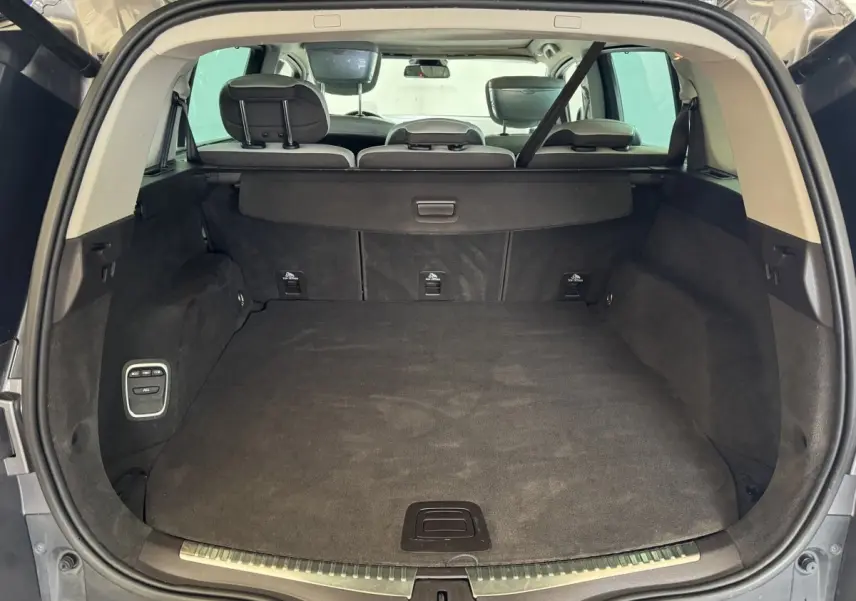 Vue arrière du coffre ouvert du Renault Espace gris foncé, montrant l'espace de chargement et les sièges arrière rabattables.