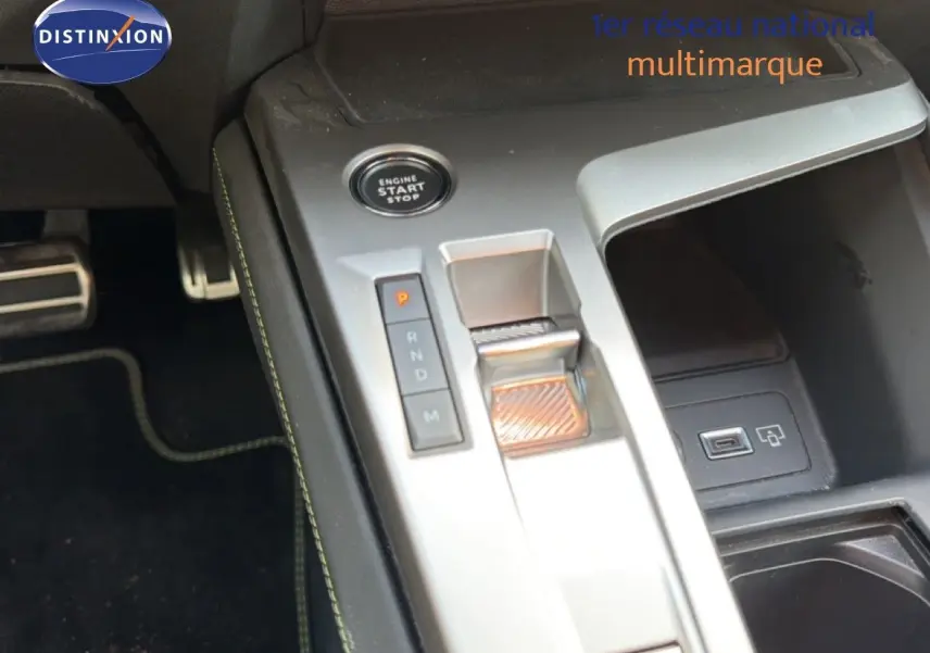 Gros plan sur la console centrale argentée de la Peugeot 408 gris selenium, avec bouton start/stop et levier de boîte auto.