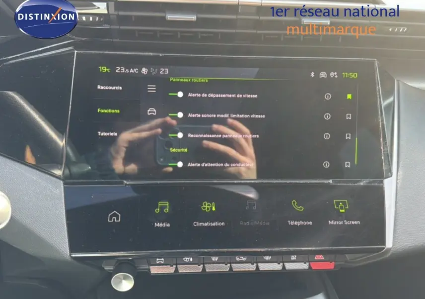 Écran tactile central du tableau de bord de la Peugeot 408 gris Selenium, affichant les réglages de sécurité et climatisation.