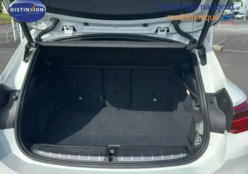 Coffre ouvert vu de l'arrière d'un BMW X2 blanc, montrant un espace de chargement propre et spacieux.