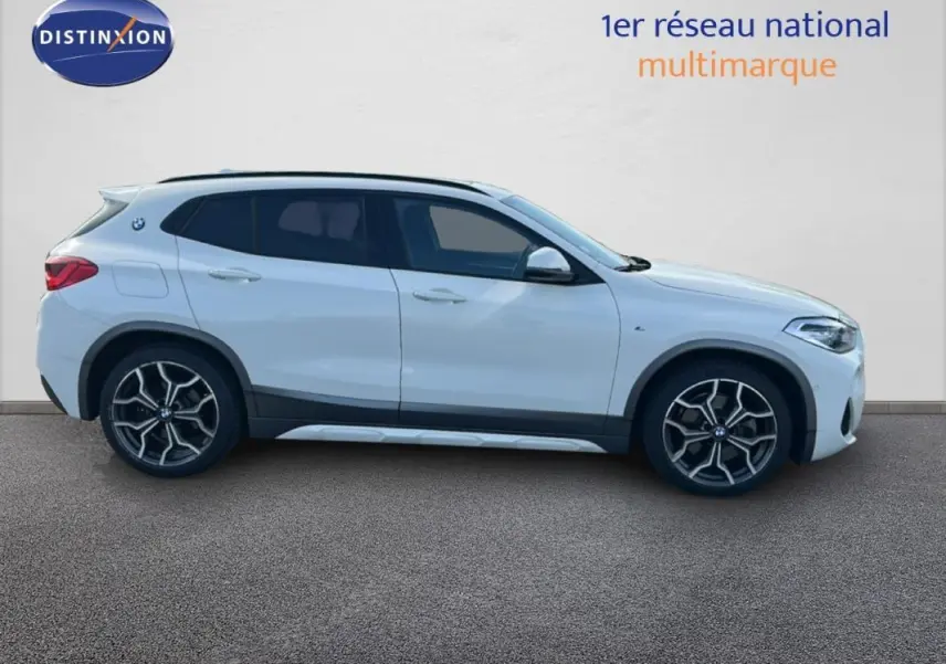 Profil droit d’un BMW X2 blanc 2018 avec jantes alliage 19 pouces et toit ouvrant panoramique visible.