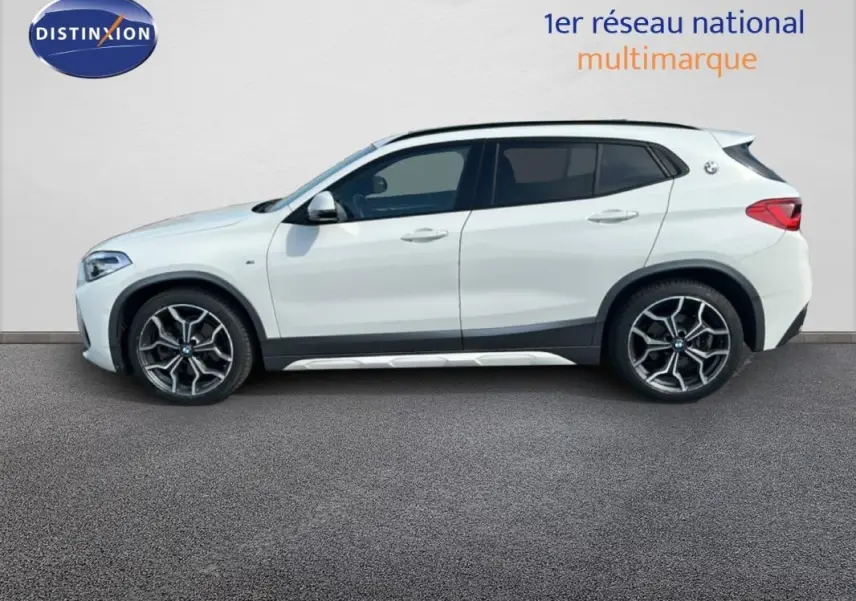 BMW X2 blanc en vue profil droit, soulignant ses jantes alliage 19 pouces et son design compact urbain.
