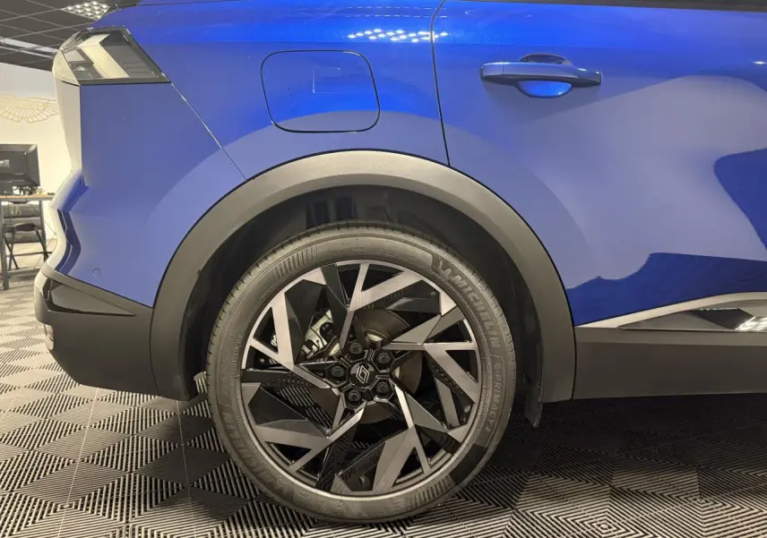 Gros plan sur la roue arrière droite bleue Renault Symbioz 2025 avec jante aluminium 19 pouces Elixir.