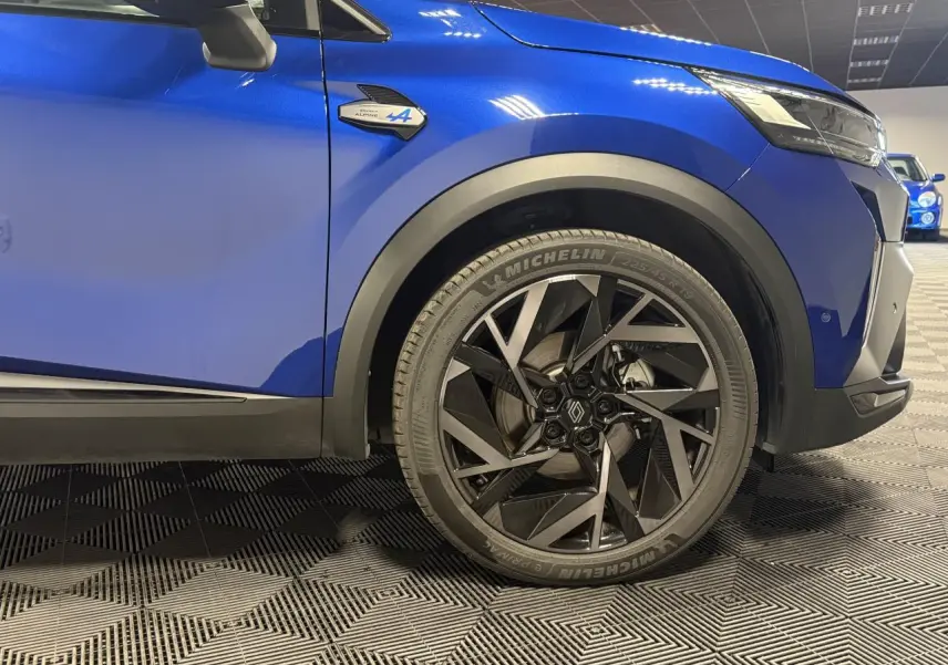 Gros plan sur la roue avant droite et l’aile bleu Iron d’un Renault SYMBIOZ Esprit Alpine avec jante aluminium 19 pouces.