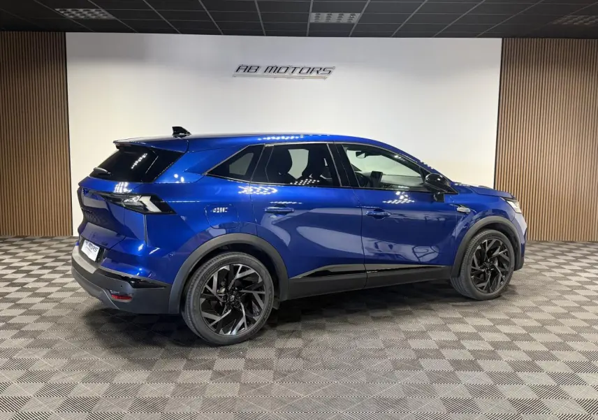 Renault Symbioz bleu Iron en vue profil droit, avec jantes noires et détails noirs brillants sur carrosserie.