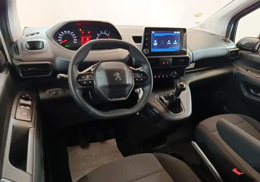Intérieur du Peugeot Partner 2020 vu de face, tableau de bord noir avec volant compact et écran tactile central.