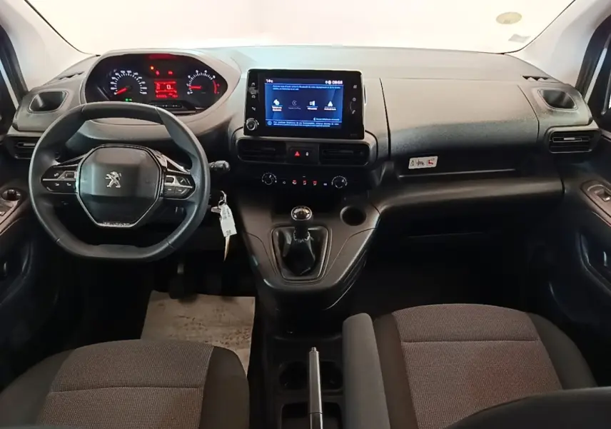 Vue intérieure avant du Peugeot Partner 2020, tableau de bord noir avec écran tactile et volant multifonction.