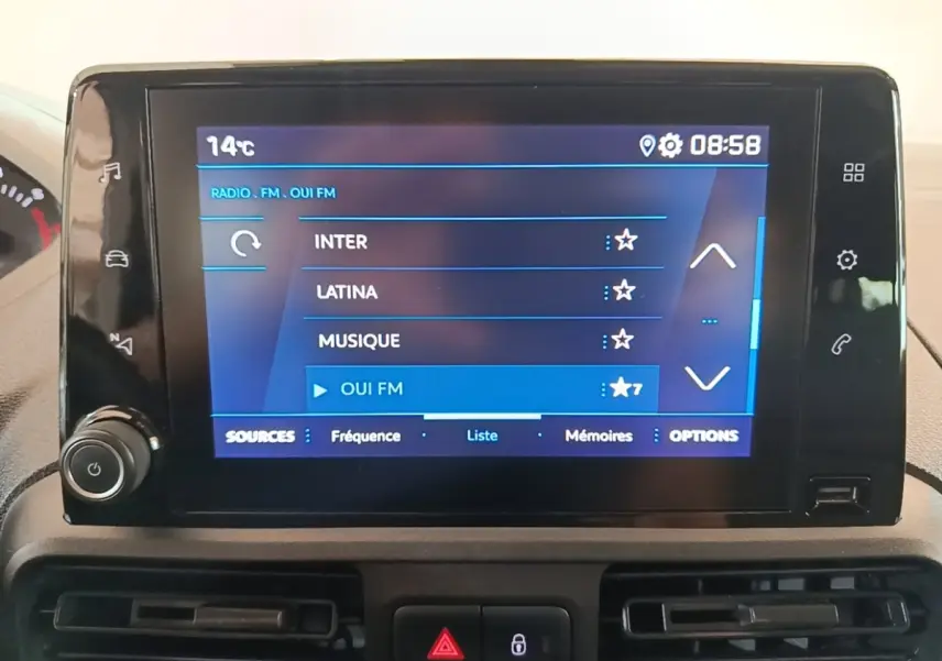 Écran tactile central du tableau de bord du Peugeot Partner 2020 affichant les stations radio FM, avec commandes autour.
