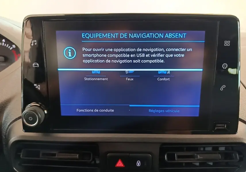 Écran central du tableau de bord du Peugeot Partner blanc, affichant un message d'absence d'équipement de navigation.