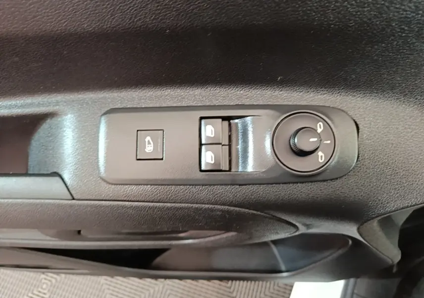 Gros plan sur les commandes de réglage des rétroviseurs et des vitres côté conducteur du Peugeot Partner blanc 2020.