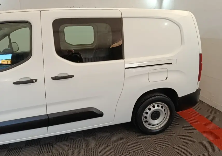 Vue latérale droite du Peugeot Partner blanc 2020 avec cabine allongée et porte latérale vitrée.