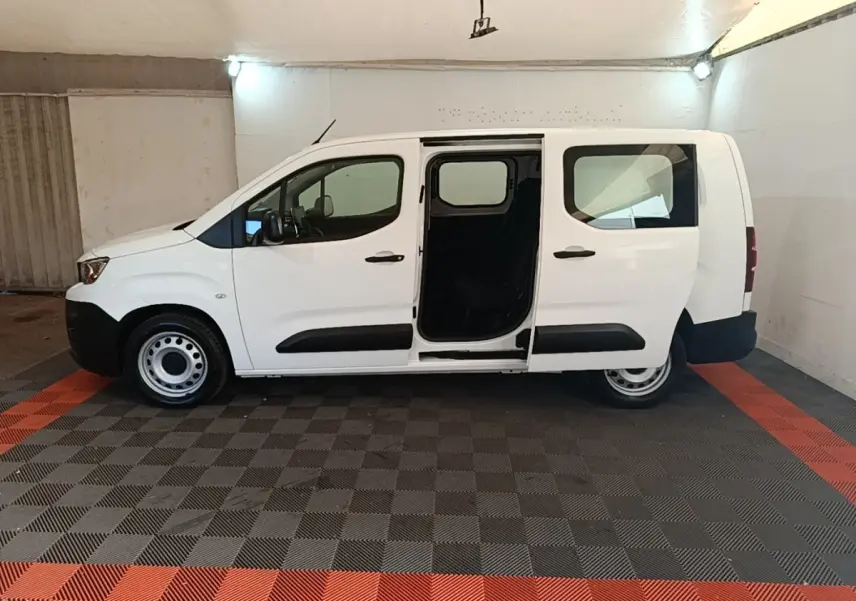Vue latérale droite d'un Peugeot Partner blanc 2020 avec porte coulissante ouverte en intérieur.
