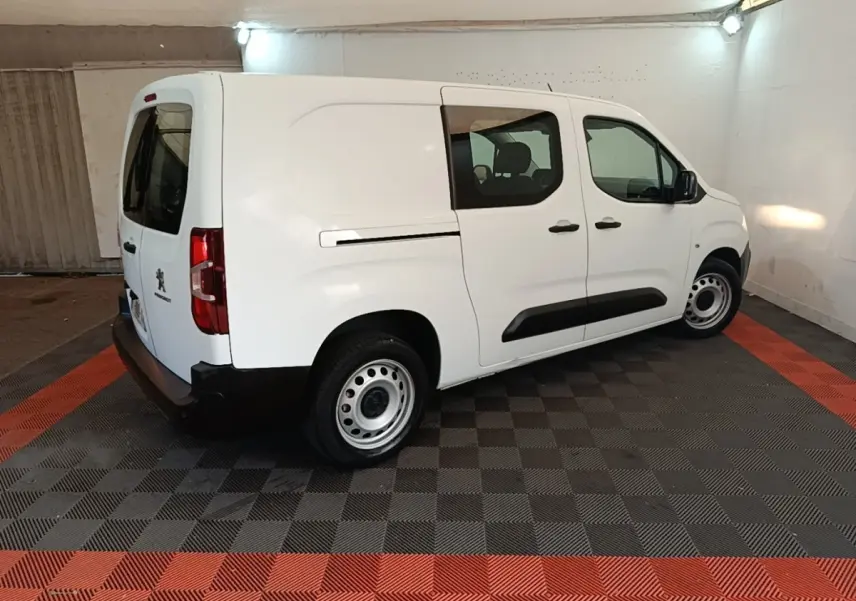 Vue 3/4 arrière droite d’un Peugeot Partner blanc 2020 en fourgon avec vitres latérales et jantes acier.