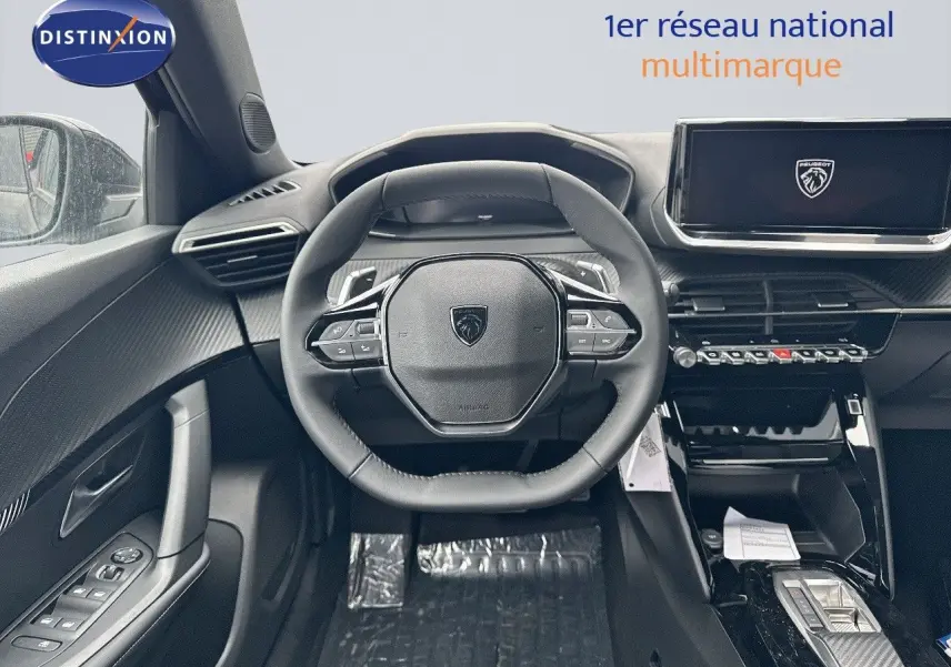 Intérieur du Peugeot 2008 Hybrid 136ch Allure 2025, vue frontale du poste de conduite avec volant cuir noir et écran tactile.